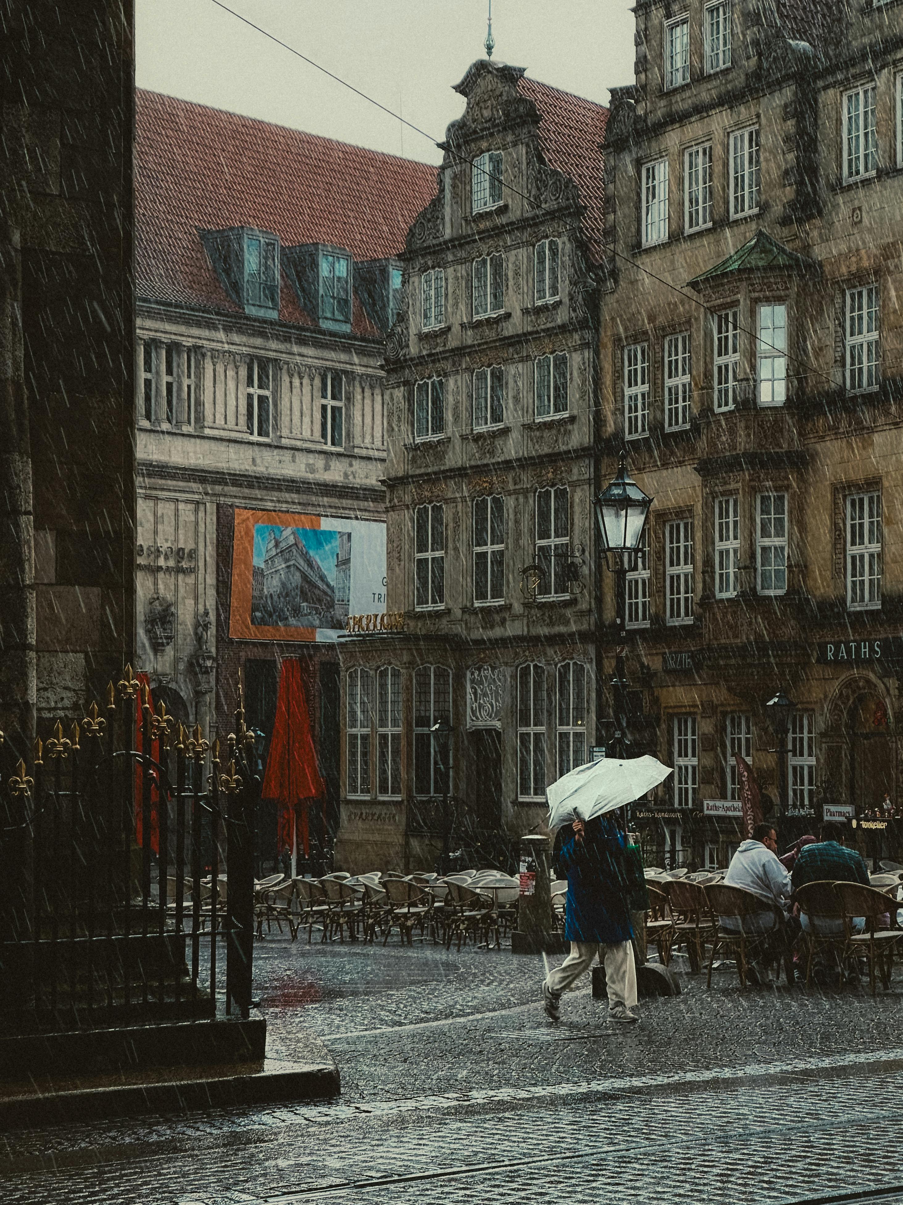 A rainy street scene in Bremen, Germany, with people and historic buildings.
