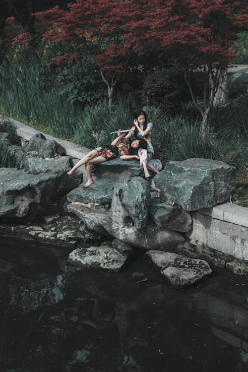 Two people sitting on rocks in a pond