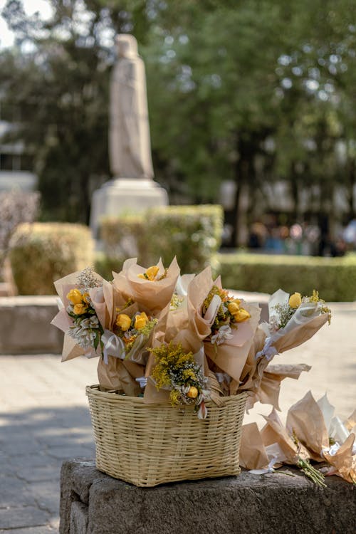 A basket of flowers sits on a stone bench