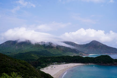 A view of a beach and mountains from a hill