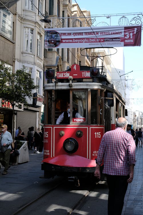 A red and white trolley car is on the street