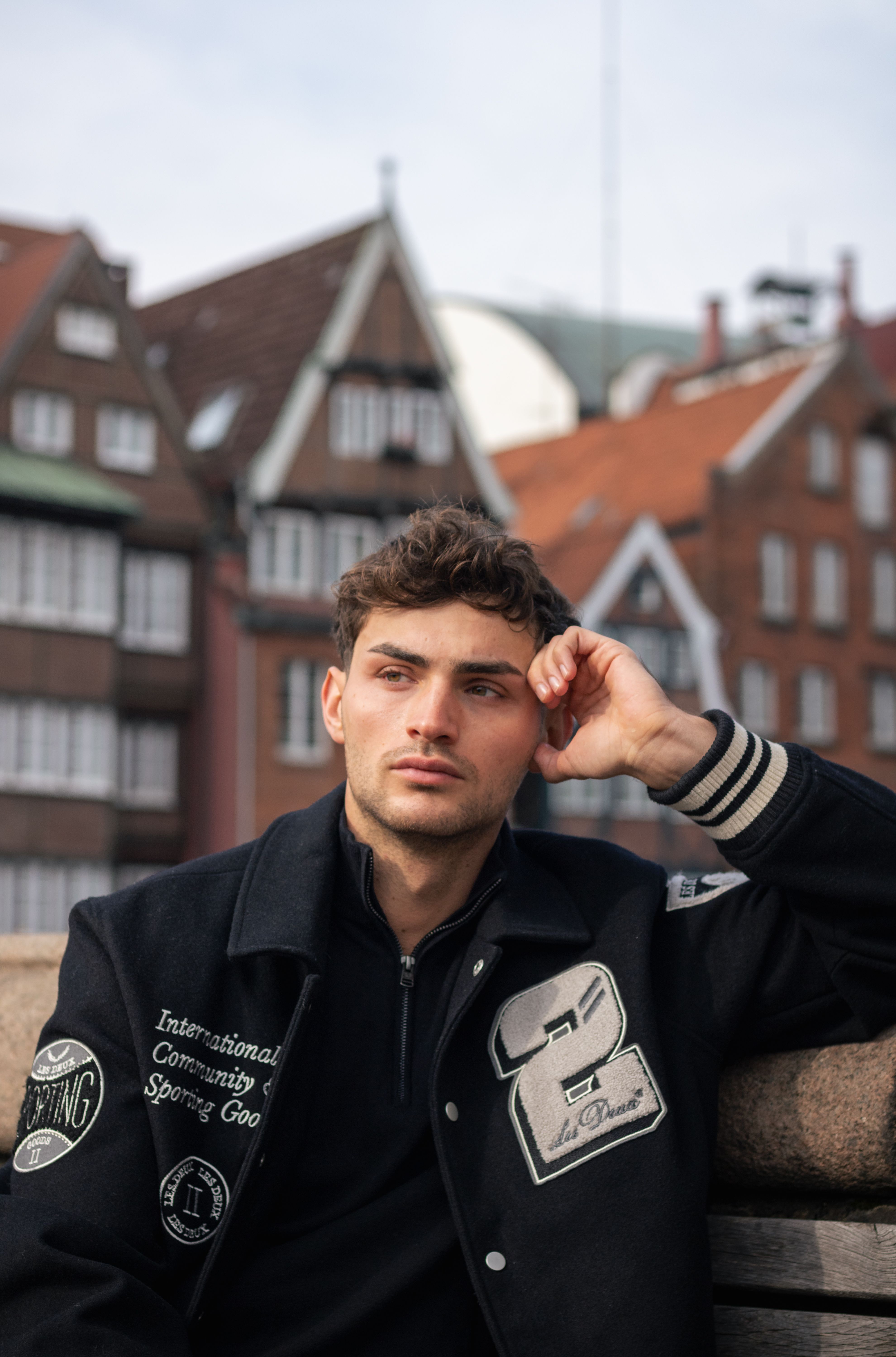 Portrait of a thoughtful man in black jacket in urban Hamburg, Germany.