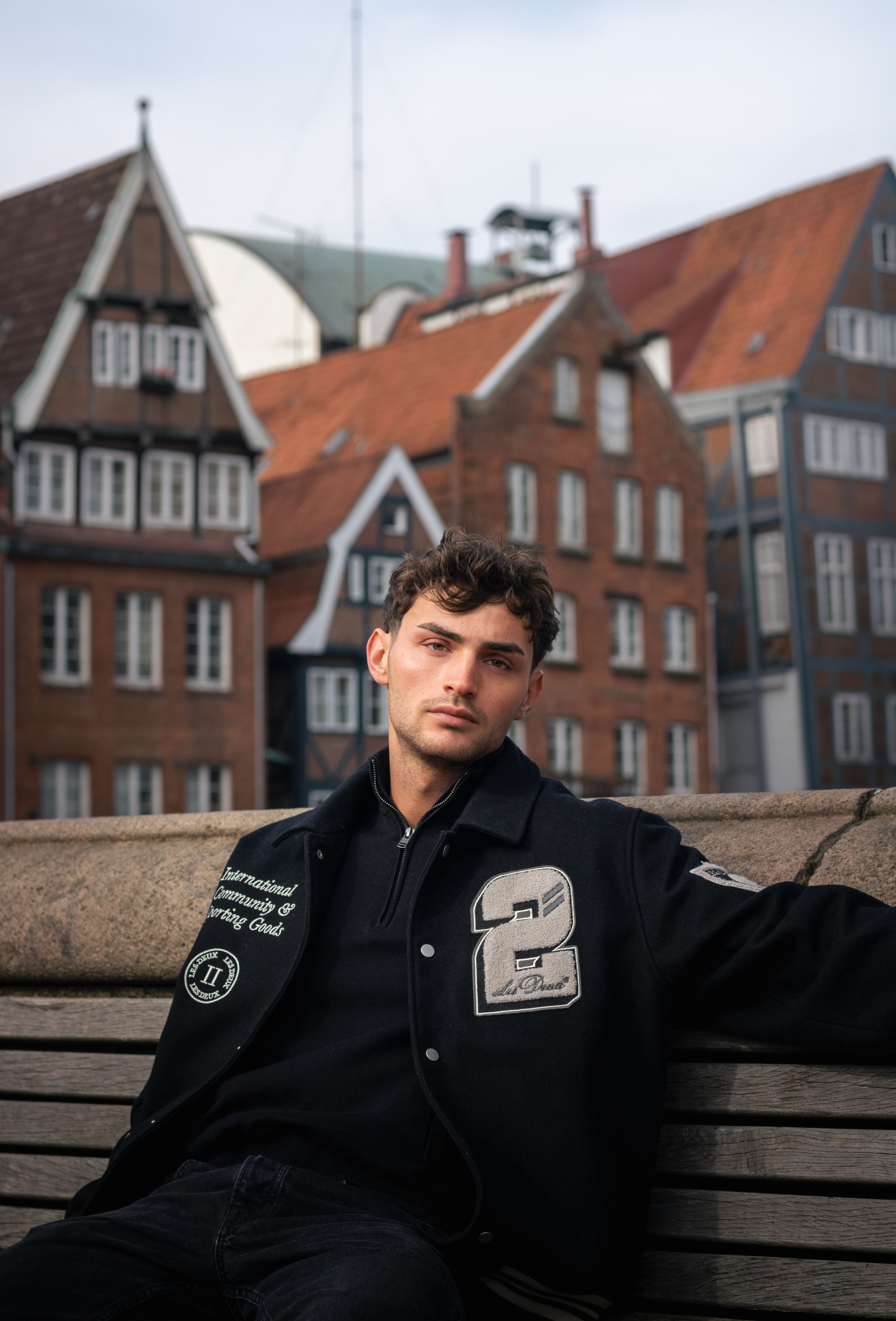 Portrait of a fashionable man in front of traditional buildings in Hamburg, Germany.