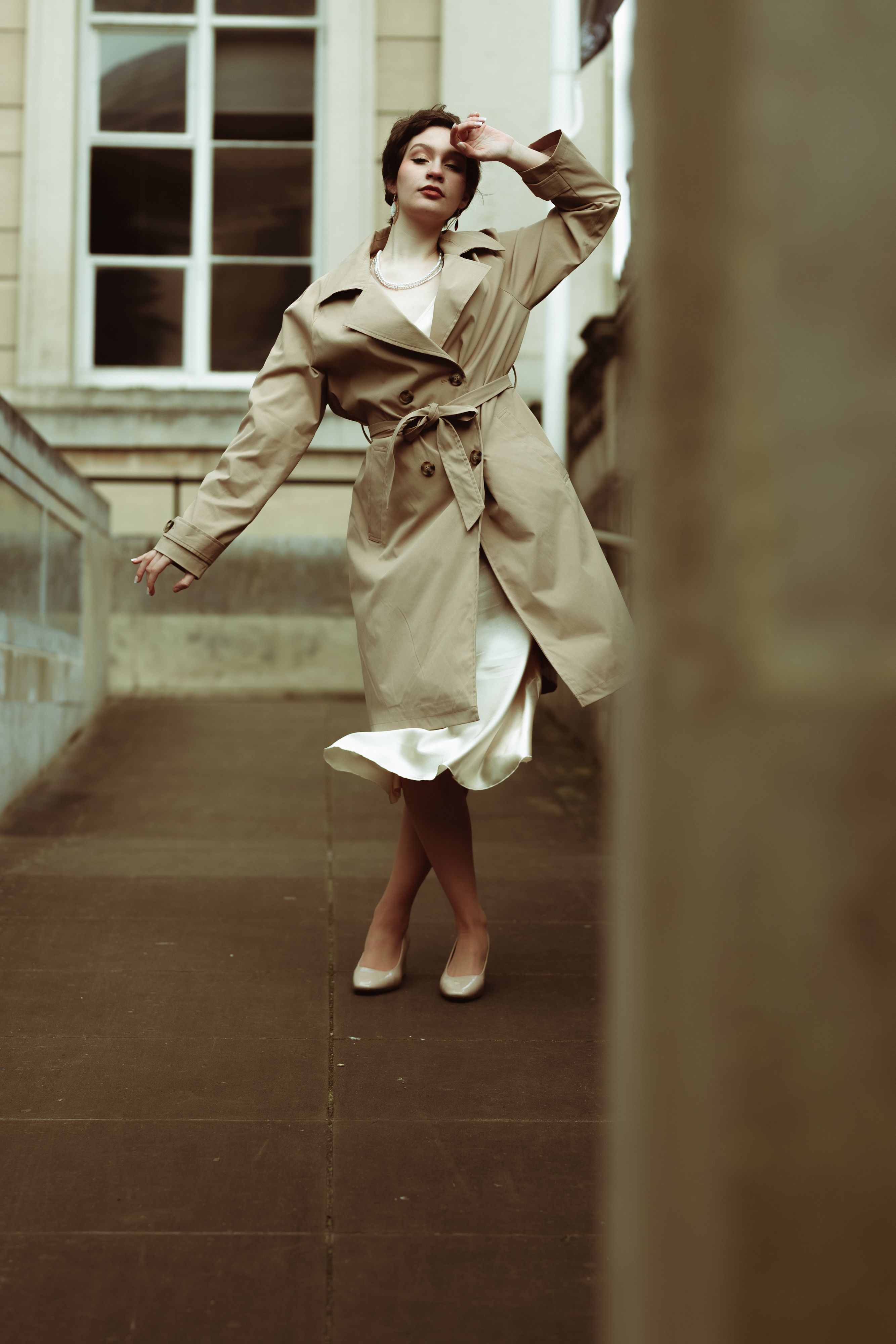 Woman in a trench coat posing for an evening look