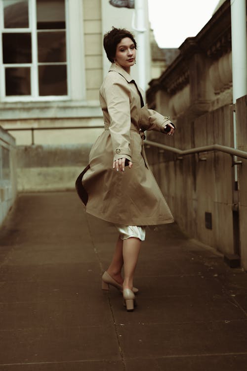 Young Woman in a Gray Trench Coat and High Heels 