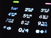 特写图：在黑暗环境中发光的手机键盘，显示数字和泰文