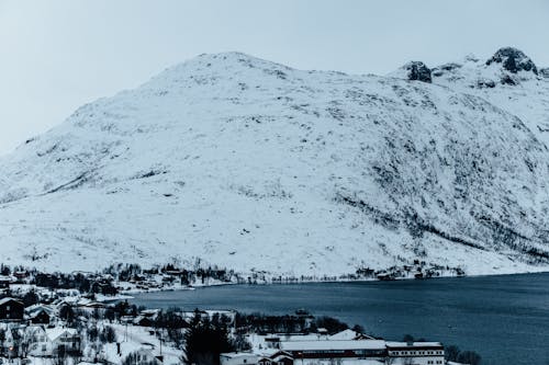 A snowy mountain with a lake in the background