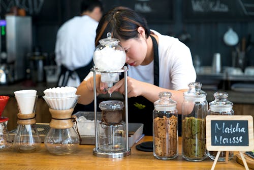 Woman Standing Facing Glass Container