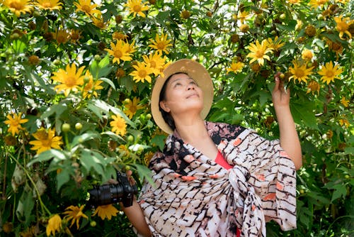 Photo of Woman Near Yellow Flowers