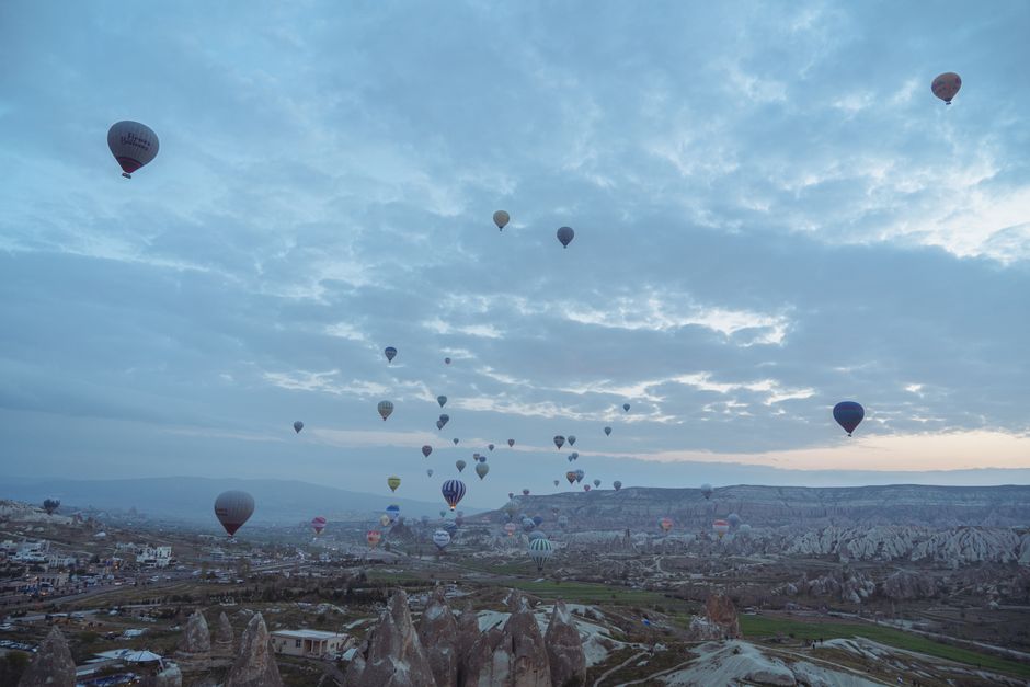 Numerous hot air balloons floating over the fairy chimneys of Cappadocia at sunrise in Turkey