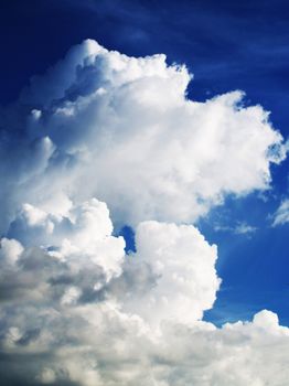 Vivid cumulus clouds on a bright day with a deep blue sky.