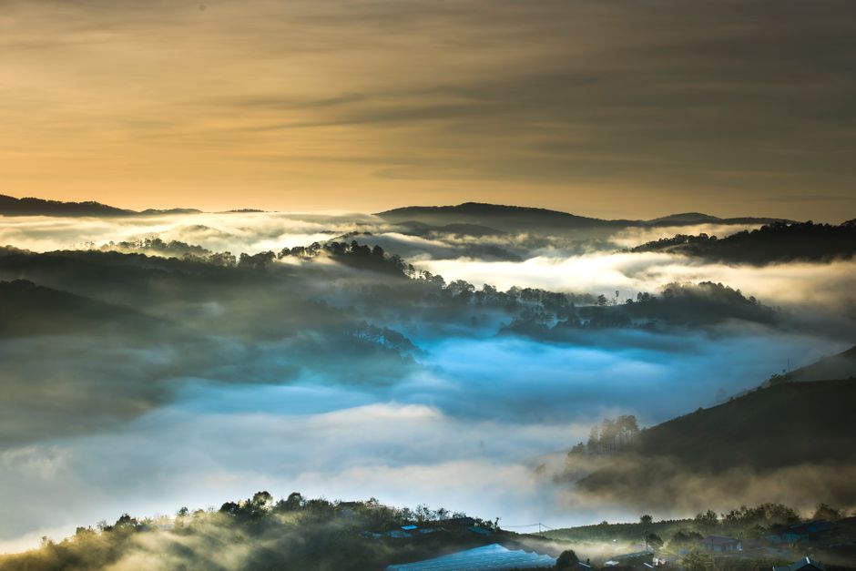 Serene sunrise over misty mountains with dramatic cloudscape view.