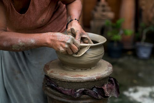 Женщина делает глиняный горшок