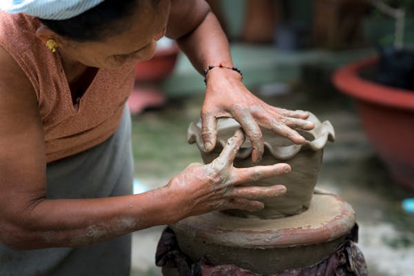 Artisan potier travaillant l'argile sur un tour dans son atelier
