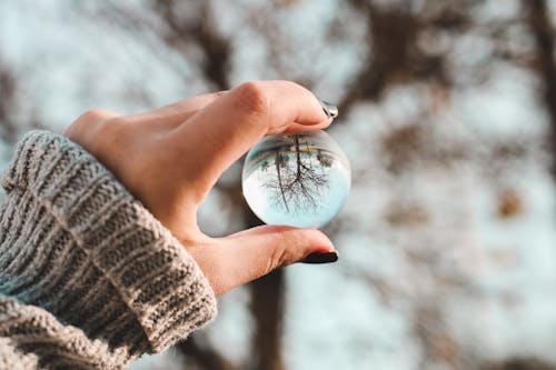 Person Holding Glass Ball