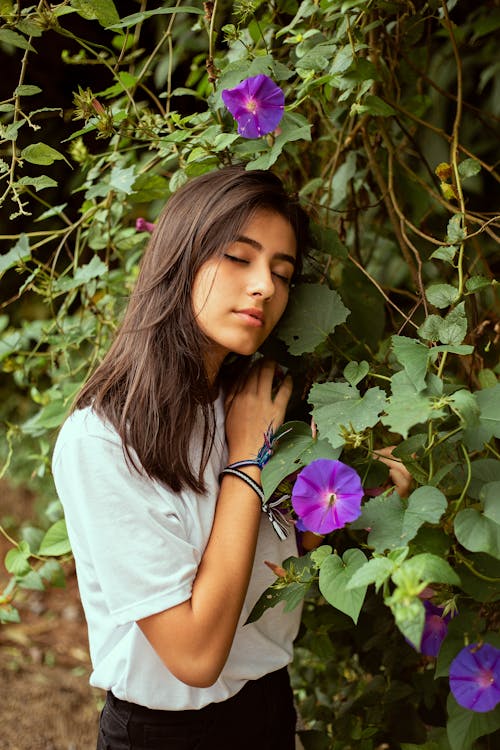 Základová fotografie zdarma na téma bílé tričko, brunetka, fialová kytka