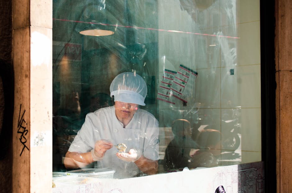 A chef working in a kitchen behind a glass window in Madrid, Spain.