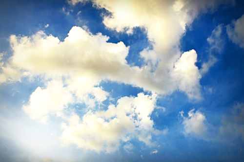 Free Idyllic cloudscape with fluffy clouds in a bright, serene blue sky. Stock Photo