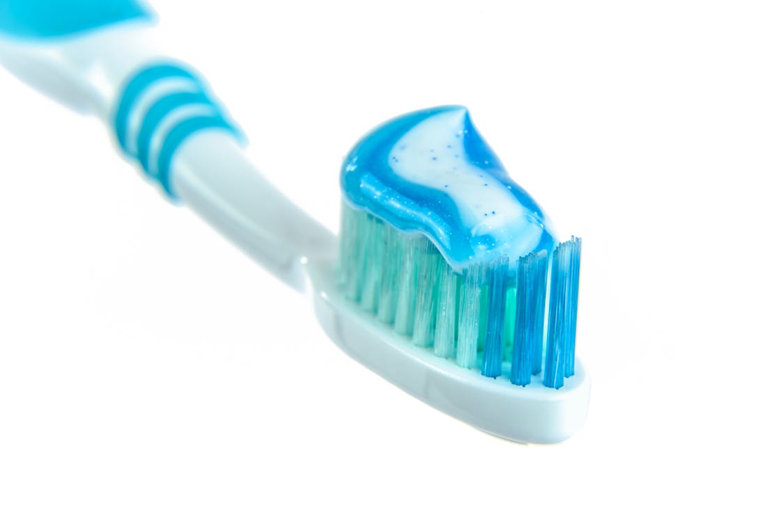 Cepillo azul de dientes con una pasta de dientes
