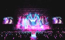 Unrecognizable singers performing on bright stage in front of public