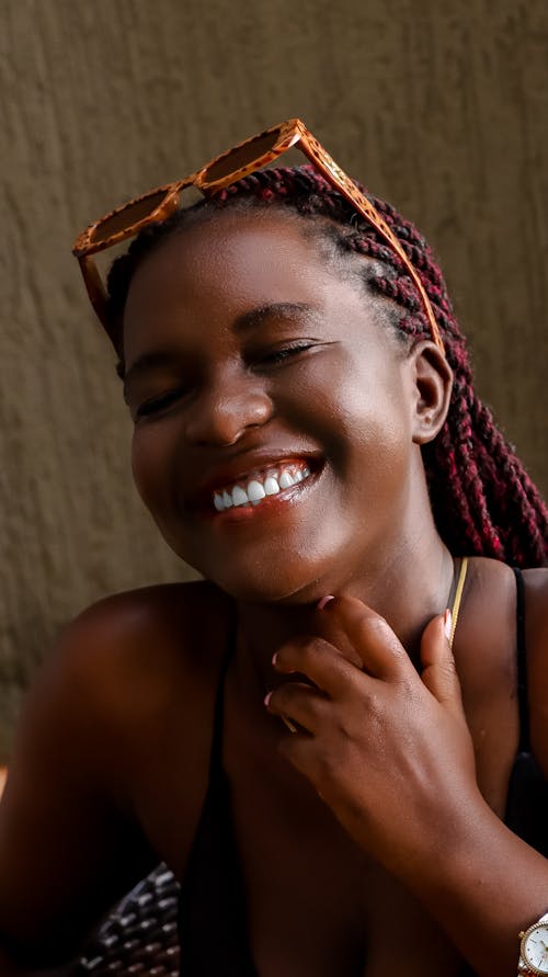 Free A smiling woman with dreadlocks and sunglasses Stock Photo