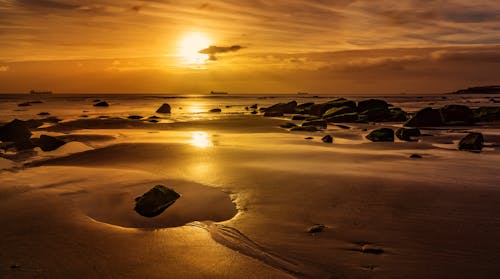 Rocky Shore by the Sea During Sunset 