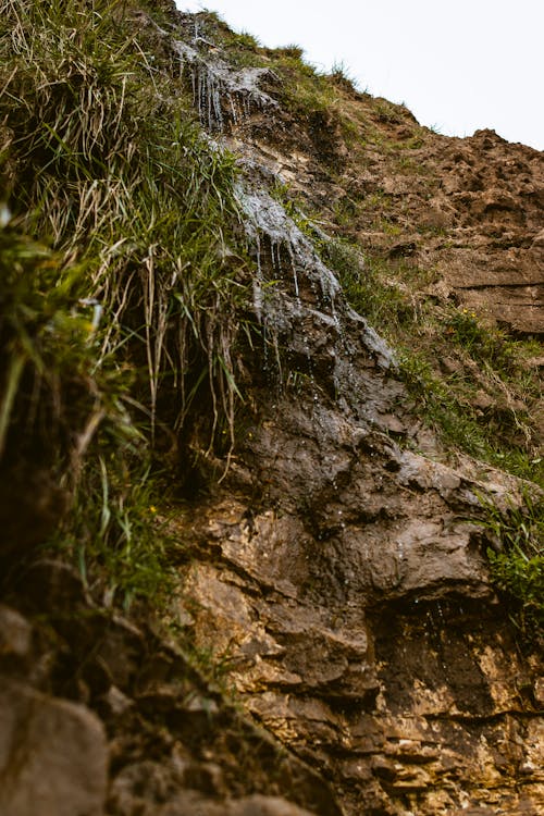 A waterfall is flowing down a cliff