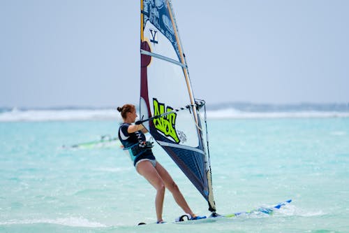 A woman windsurfing in the ocean with a board