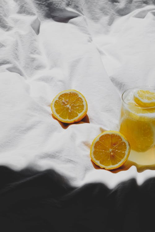 Free A glass of lemonade on a bed with two slices of lemon Stock Photo