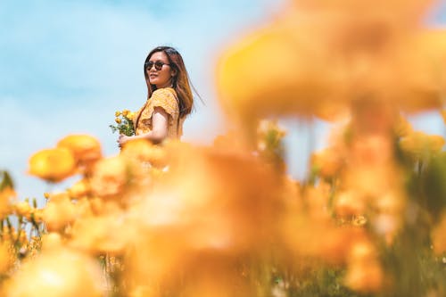 Woman Standing While Holding Yellow Flowers