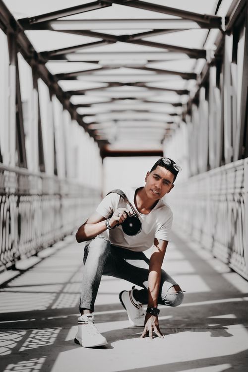 Man Sitting on Gray Bridge · Free Stock Photo