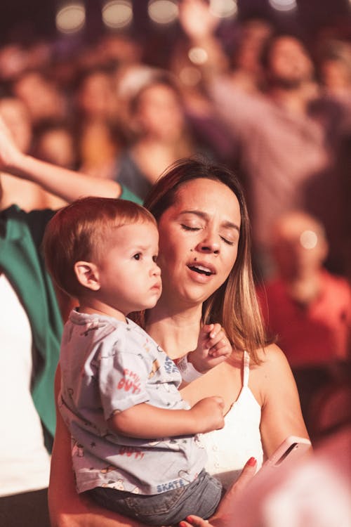 Free Woman Holding a Baby on a Festival  Stock Photo