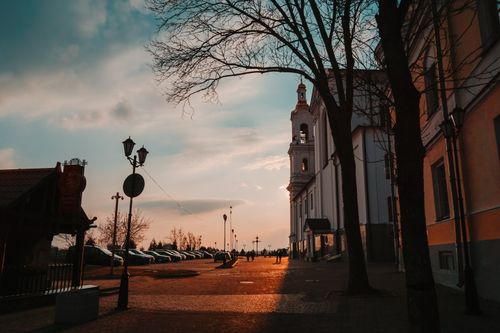 Free A stunning sunset over a historic church and street in Vitebsk, Belarus, capturing urban tranquility. Stock Photo