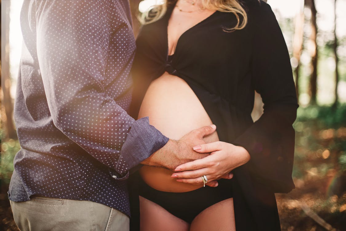 Free Man Touching Woman's Baby Bump Stock Photo