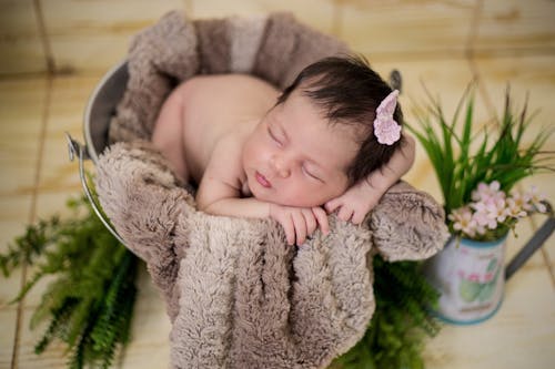 Baby Sleeping On Brown Textile