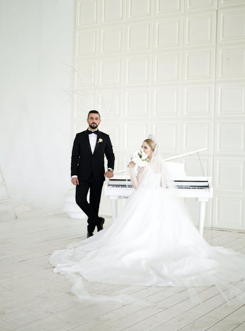 Free A bride and groom standing in front of a piano Stock Photo