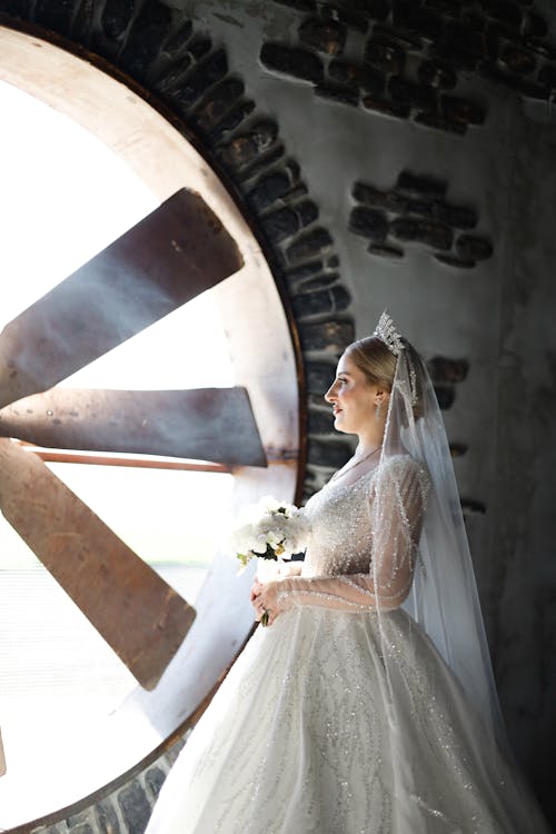 A bride standing in front of a large wheel
