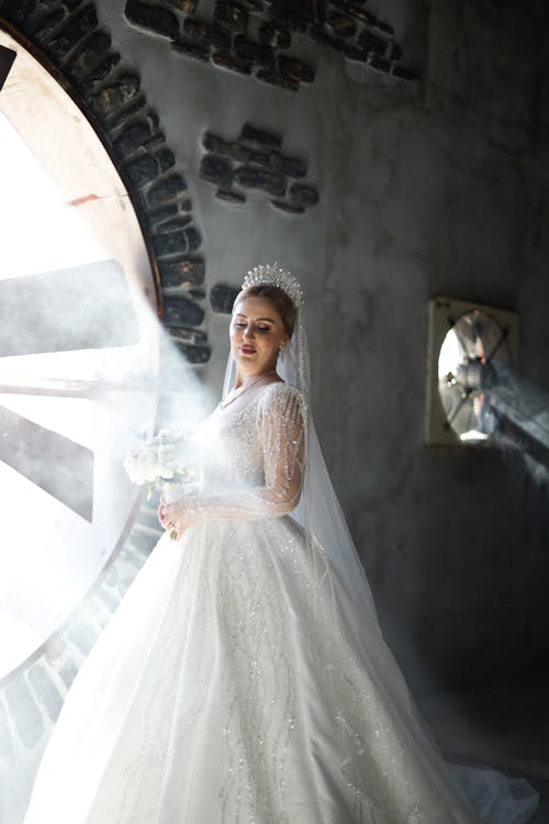 A bride in a wedding dress standing in front of a large wheel
