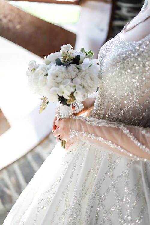 A bride holding a bouquet in her wedding dress