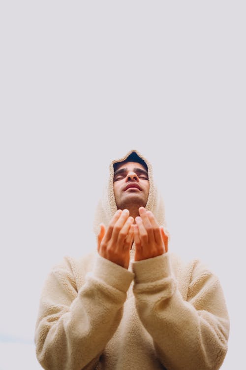 A man in a hoodie praying