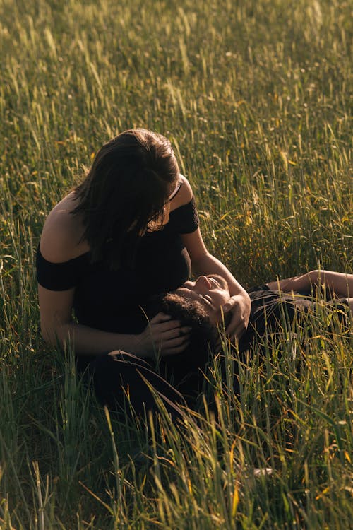 Free A woman is laying down in a field of tall grass Stock Photo