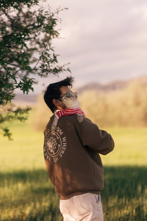 Free A man wearing a mask and holding a dog in a field Stock Photo