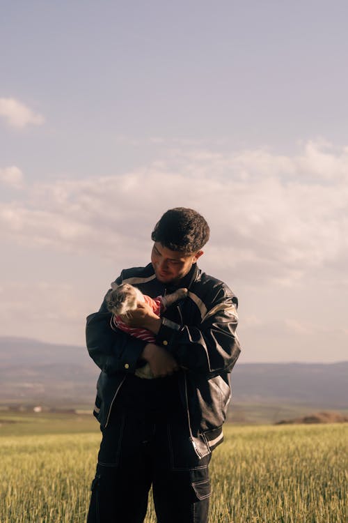 A man holding a baby in a field