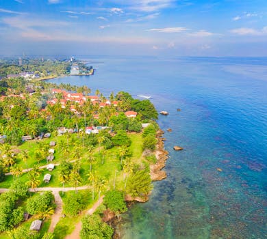 Stunning aerial view of Banten, Indonesia's coastline with lush greenery and clear blue waters.