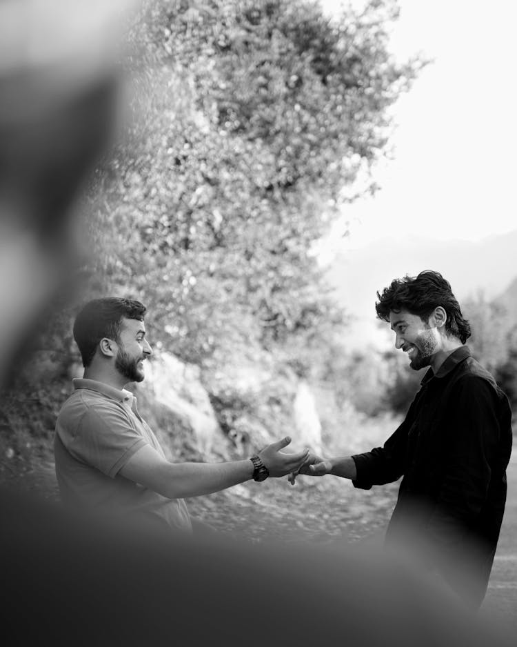 Men Talking On A Field In Black And White 