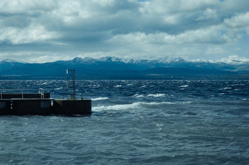 A pier with a boat and mountains in the background