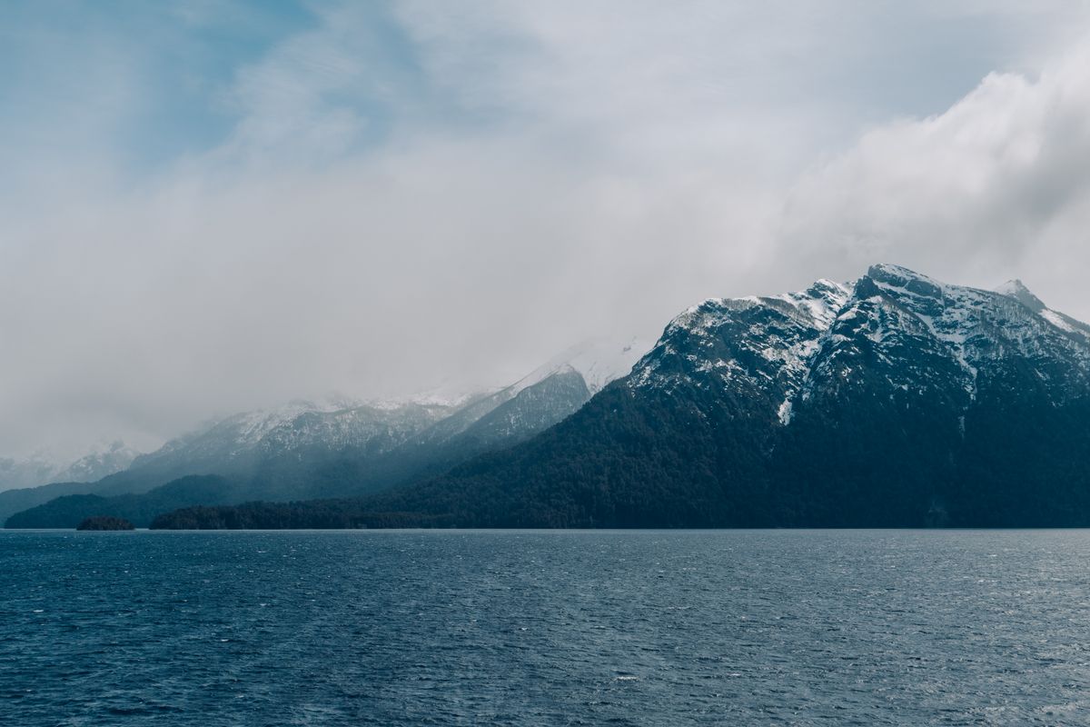 Snow-capped mountains reflected in a calm alpine lake near Bariloche, Argentina