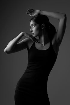 Stylish black and white portrait of a woman in a sleek black dress, exuding elegance.
