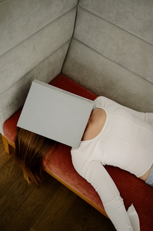 A woman with her head on top of a couch