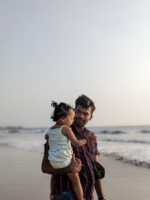 Free A man holding a child on the beach Stock Photo